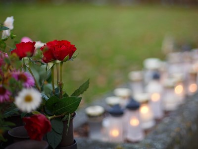Blomster foran lys på en kirkegård